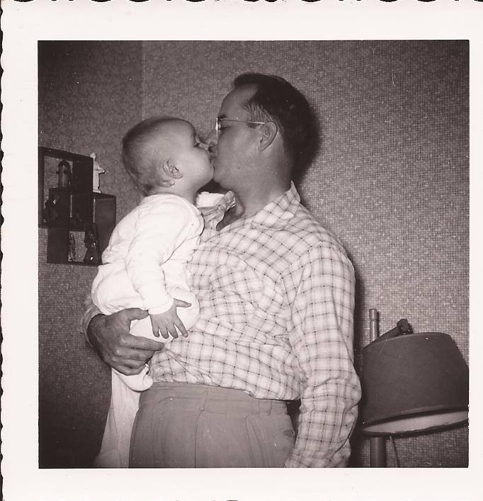 Grandpa kissing Dad as a baby